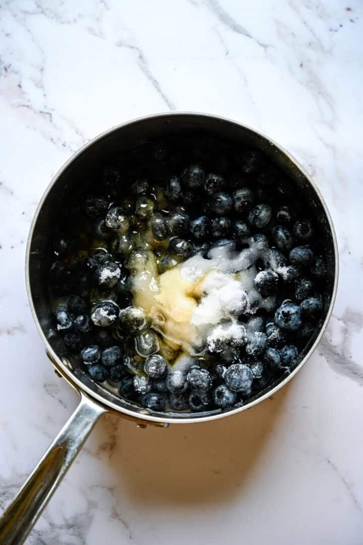 bosbessen, suiker, honing en water in een pan vóór het koken.