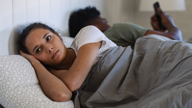 Vrouw die er gestresst uitziet terwijl ze in bed ligt