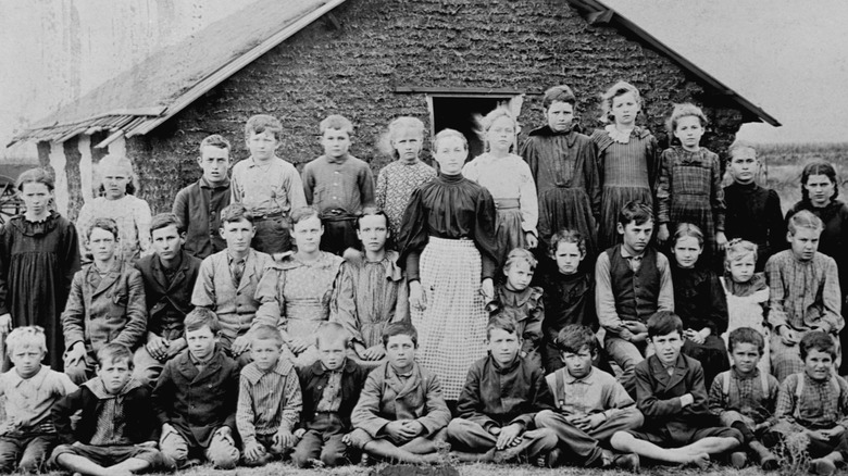 kinderen en volwassenen voor een klein huis in de prairie in de 19e eeuw