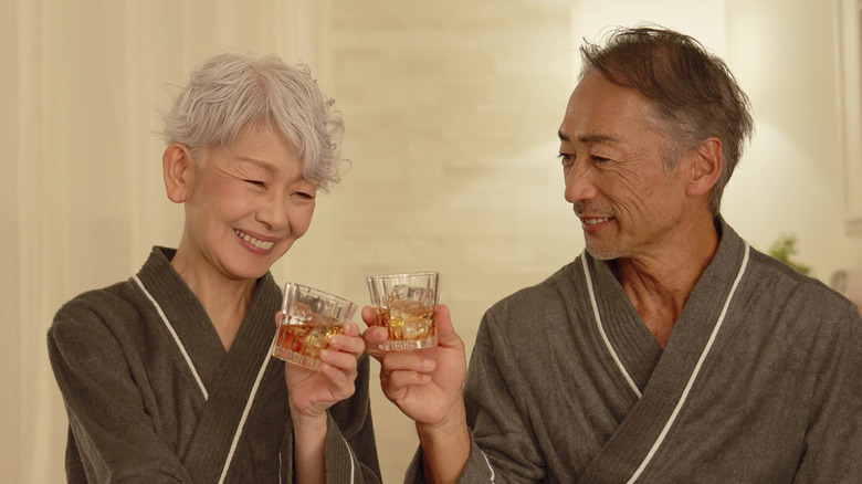 Senior koppel roosteren met whisky slaapmutsje in hotelkamer