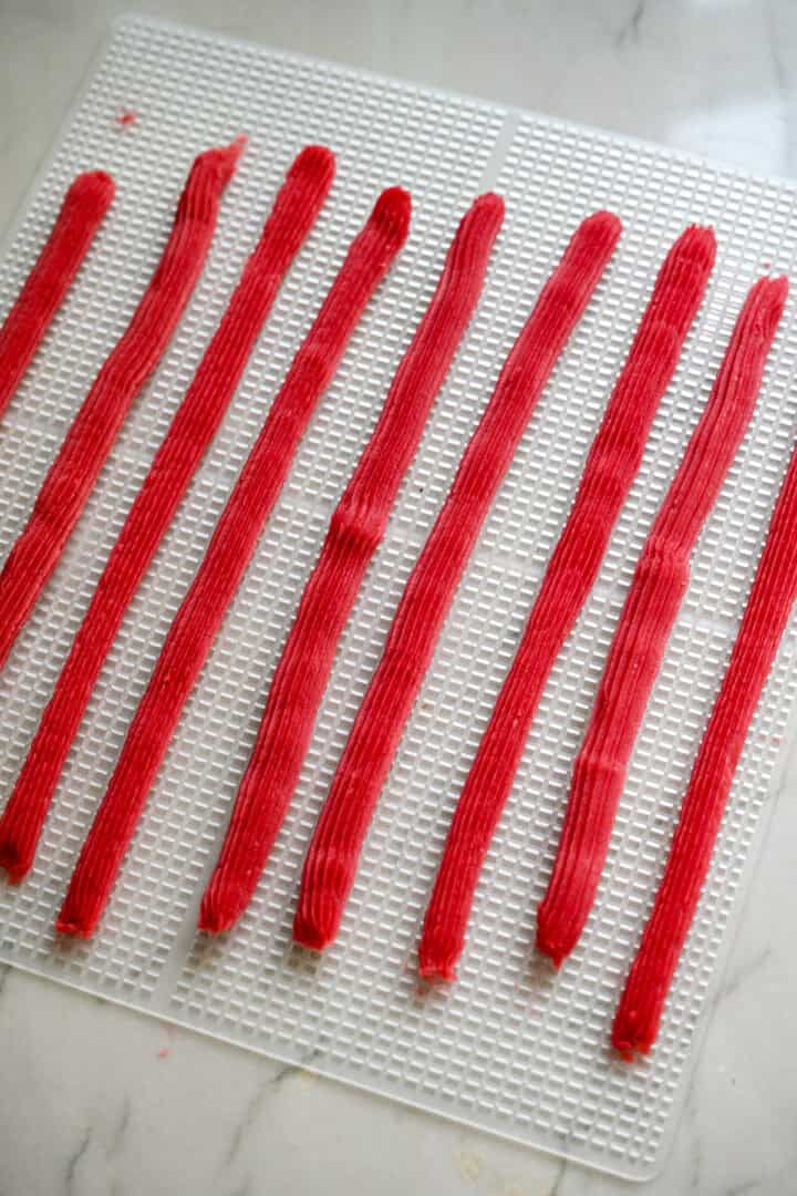 Bovenaanzicht van twizzlers op een dehydratorbak.
