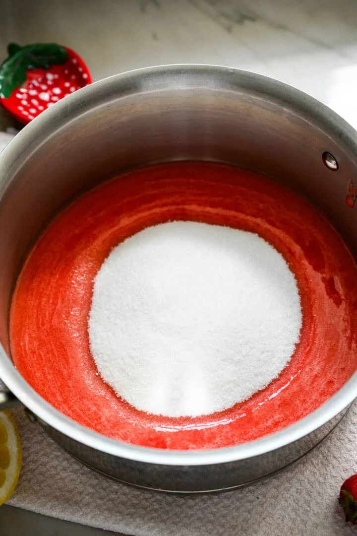 Bovenaanzicht van aardbeienpuree en suiker.