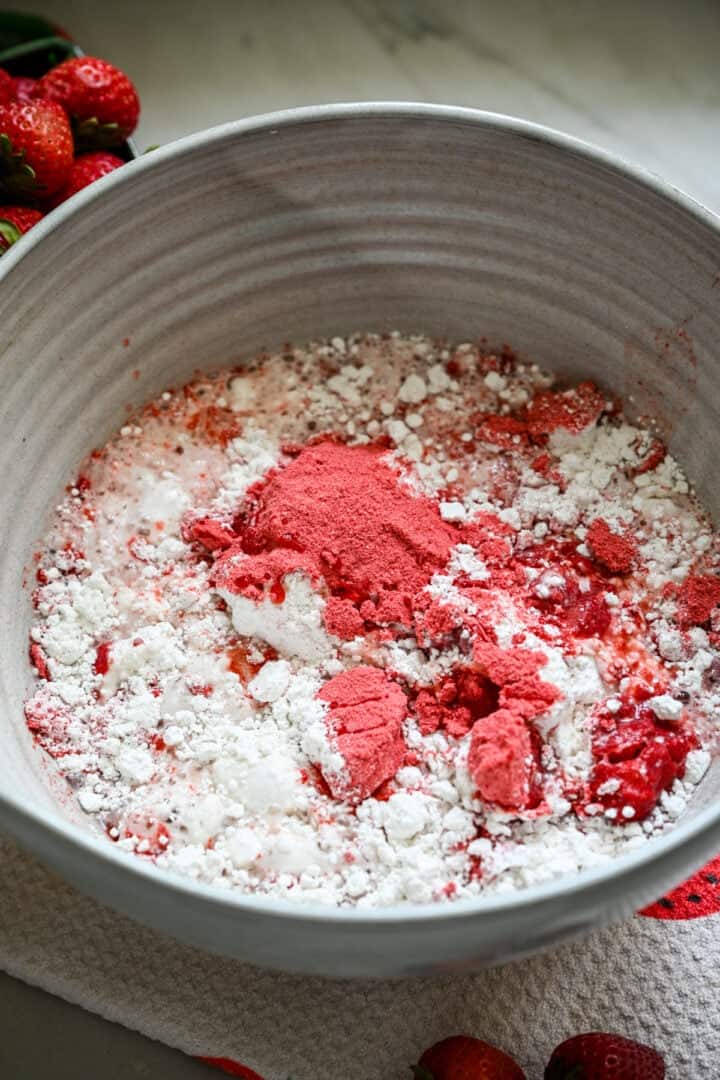 Aardbeienpoeder, cakemeel en water in een mengkom.