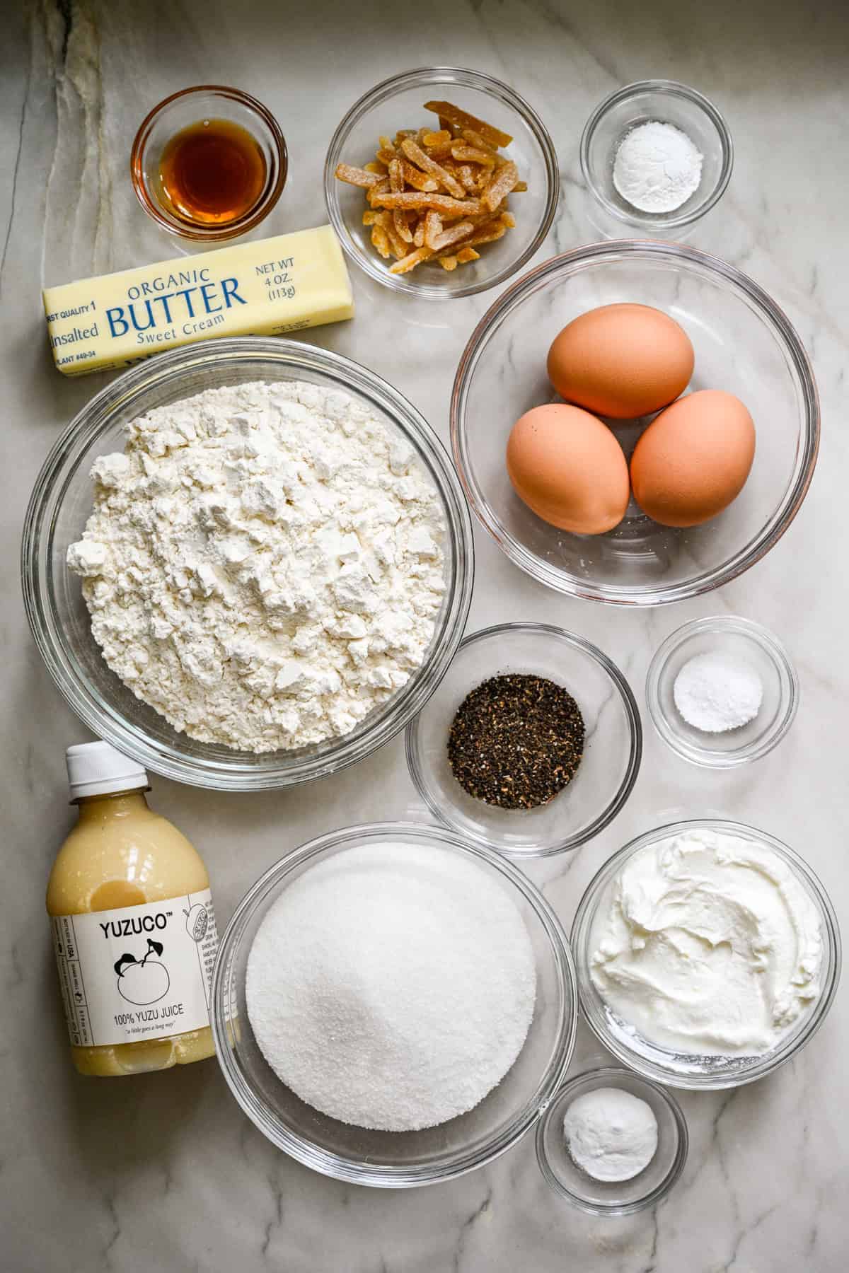 bovenaanzicht van ingrediënten voor yuzu Earl Grey-broodcake in individuele kommen.