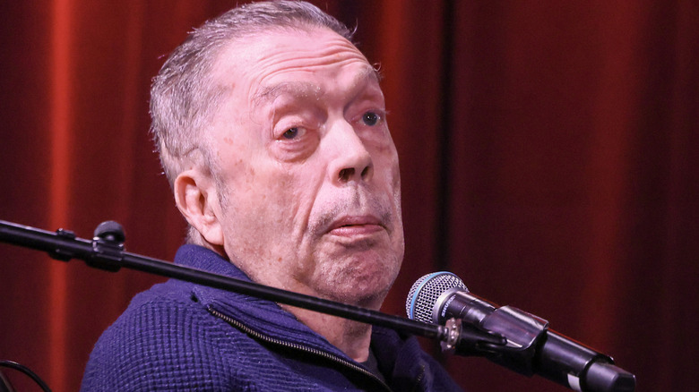 Tim Curry voor een microfoon