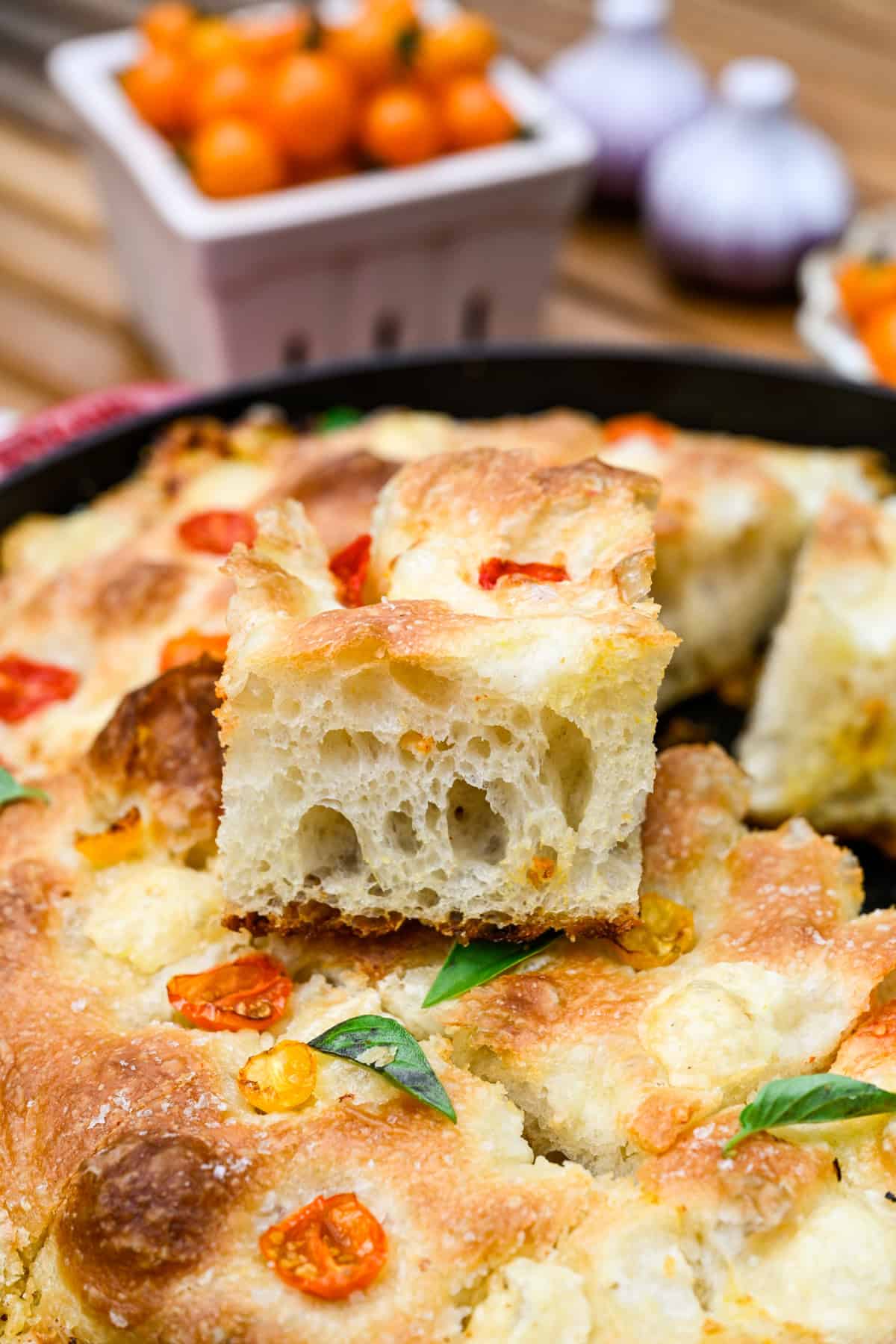 Een plakje tomaat-basilicumfocaccia bovenop de rest van het brood.