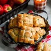 Bovenaanzicht van verschillende appelhandtaarten op een rustiek dienblad.