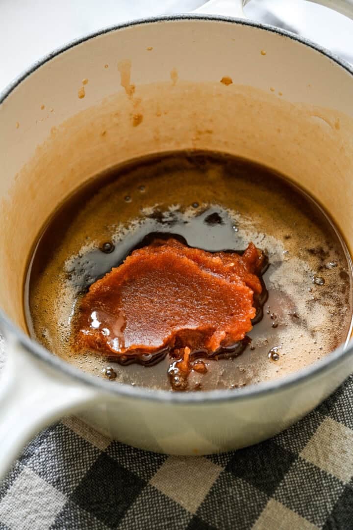 Dadelpasta toegevoegd aan het boter- en ahornsiroopmengsel in de pot.