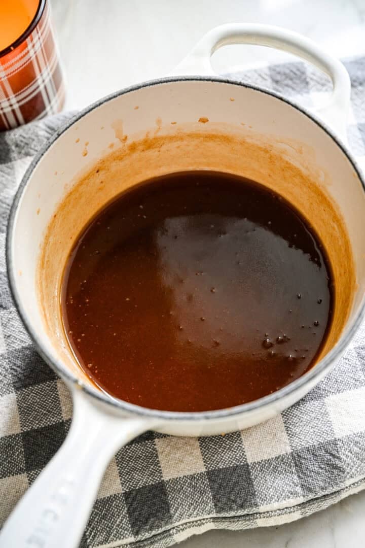 Afgewerkte dadelkaramelsaus in een kleine witte pan.