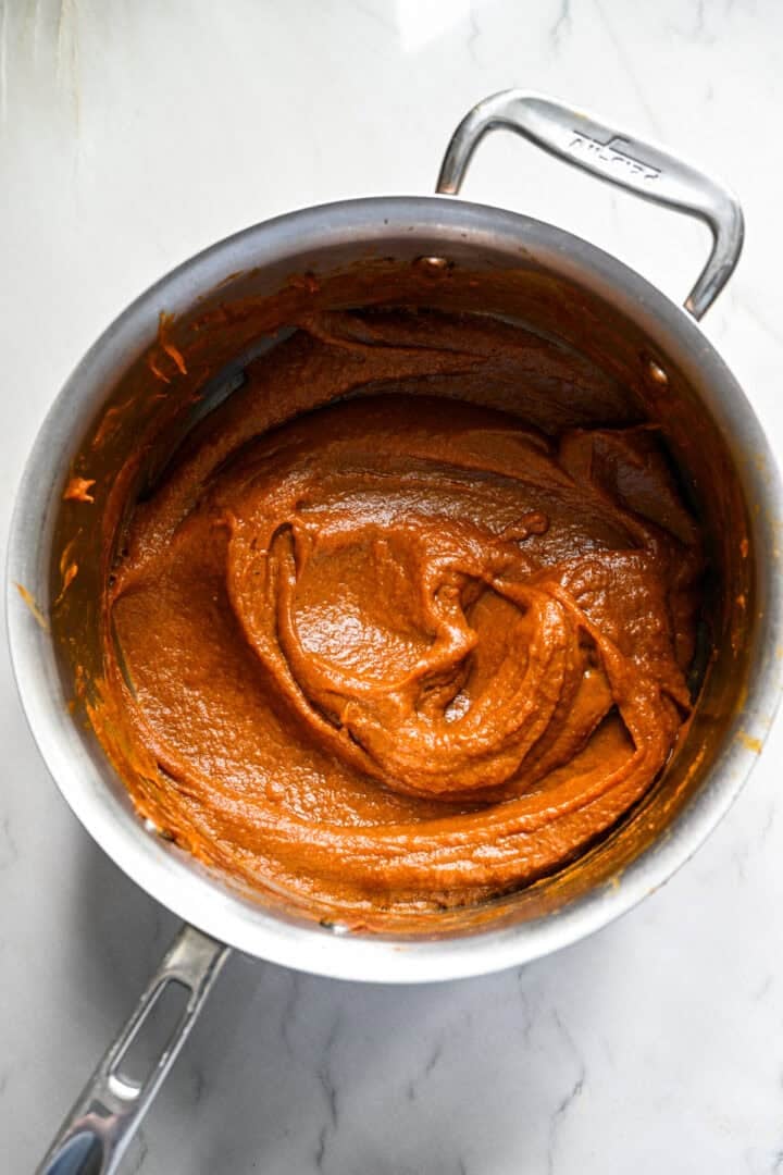 Zelfgemaakte pompoenboter in een pan nadat deze tot een dikke pasta is gekookt.