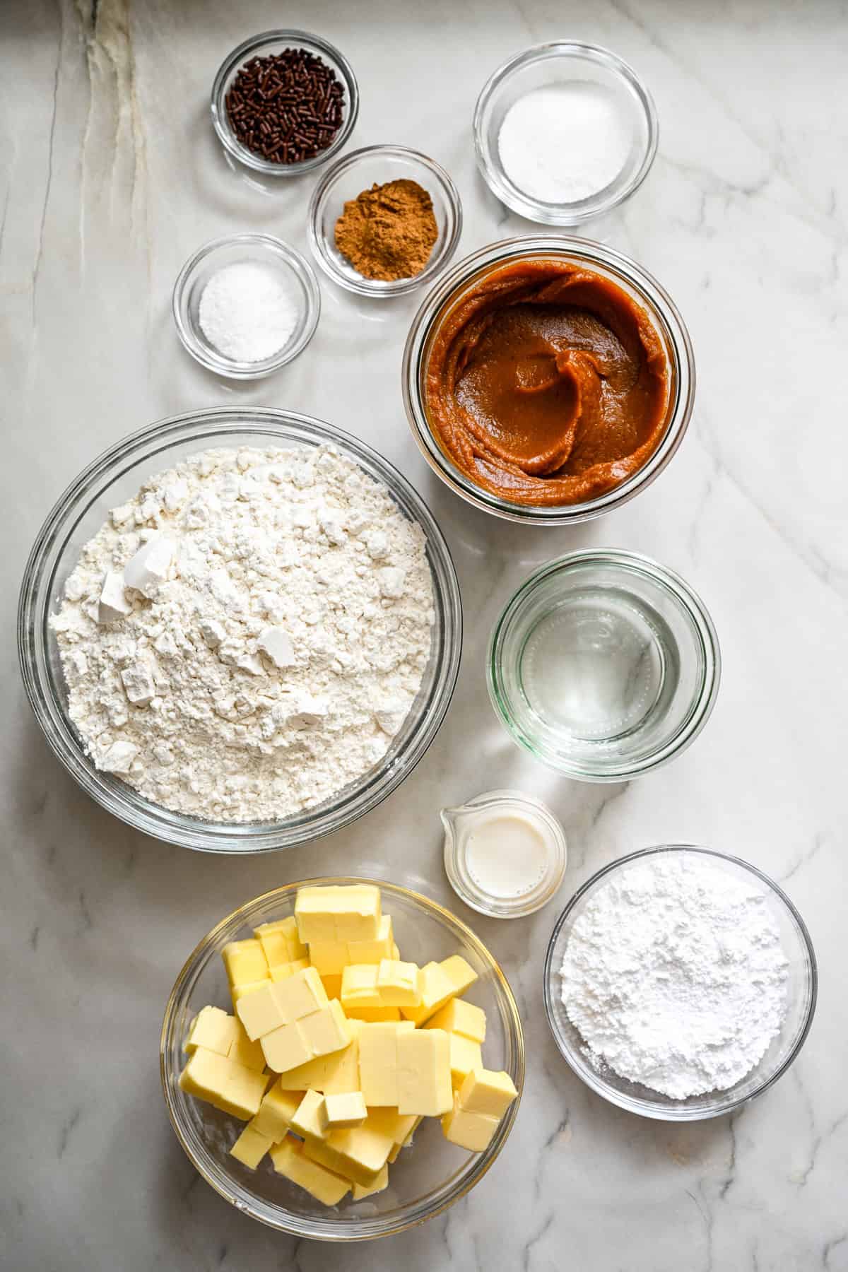 Bovenaanzicht van ingrediënten voor pompoentaart-pop-tarts in aparte kommen. 