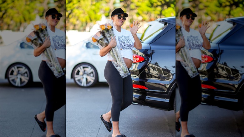 Chrissy Teigen loopt en draagt ​​bloemen