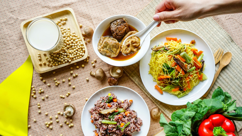 Een hand die vegetarisch eten uit een kom opschept