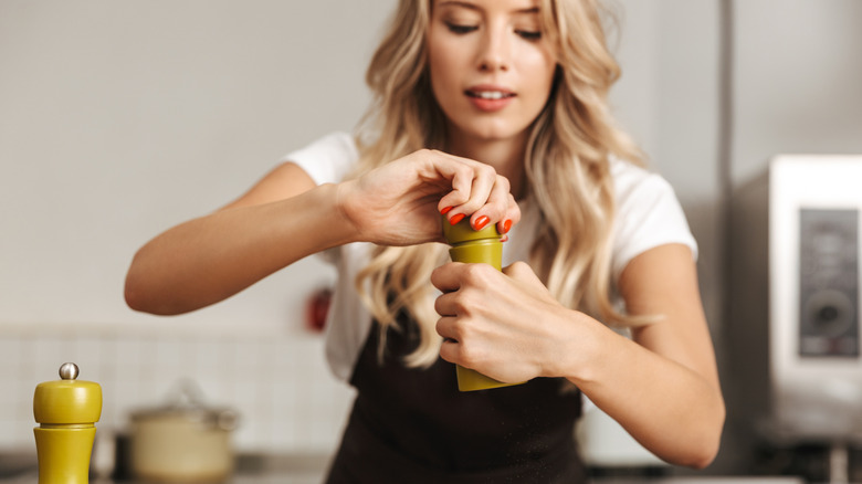 Vrouw voegt zout toe aan haar eten