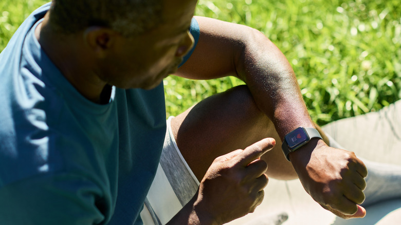 jonge man die de gezondheidsapp controleert op zijn smartwatch