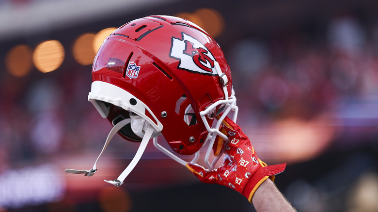 De hand van Travis Kelce houdt zijn Kansas City Chiefs-helm omhoog tijdens een wedstrijd