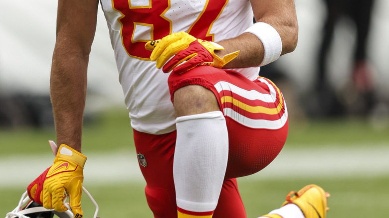 Travis Kelce met zijn hand op zijn knie tijdens een wedstrijd van 2023