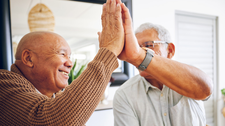 Twee oudere mannen geven elkaar een high five
