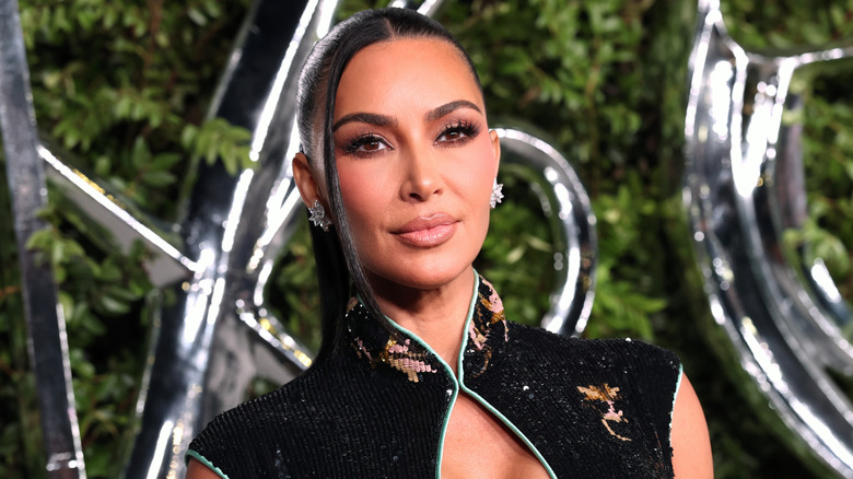 Kim Kardashian in een jurk met een Aziatische halslijn gloeit voor de foto
