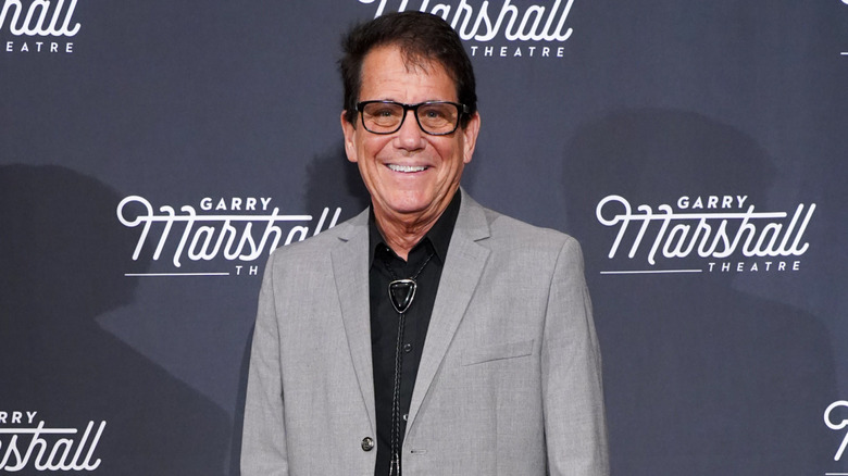 Anson Williams glimlachend in een grijs colbert