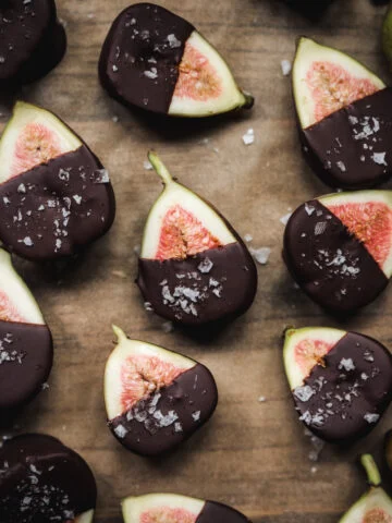 Bovenaanzicht van gehalveerde vijgen gedoopt in pure chocolade en bestrooid met zeezout.