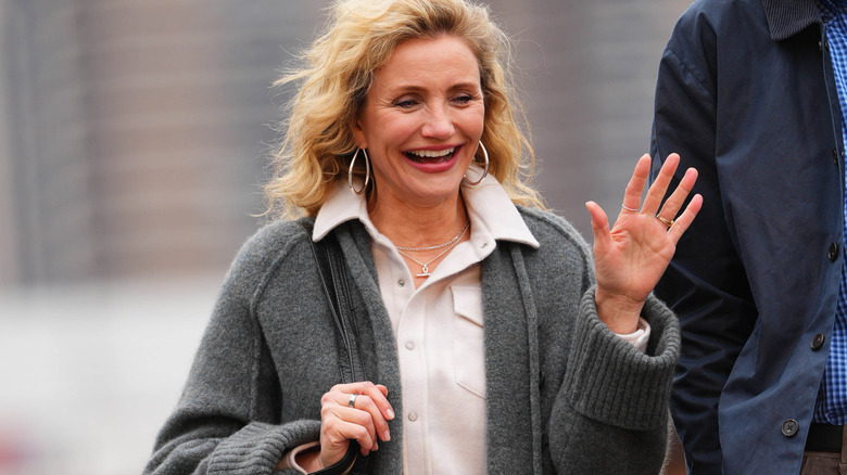 Cameron Diaz zwaait en lacht terwijl ze door de straat loopt