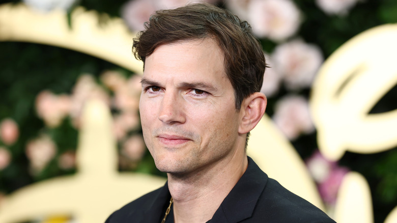 Ashton Kutcher poseert in een zwart shirt voor een publiciteitsfoto