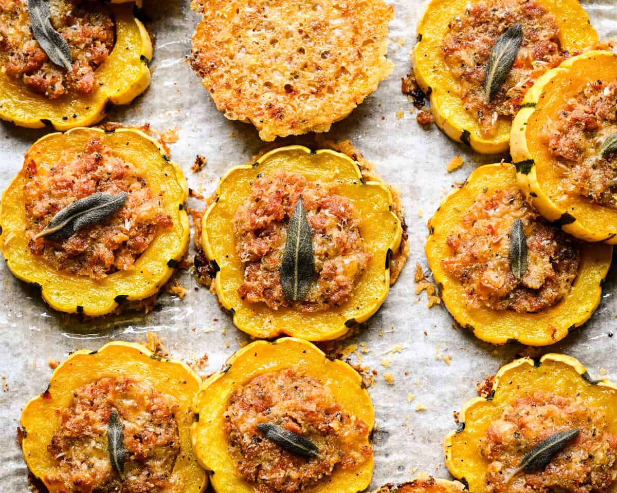 Close-up van gevulde delicata squashringen en een Parmezaanse kaaschips op perkament.