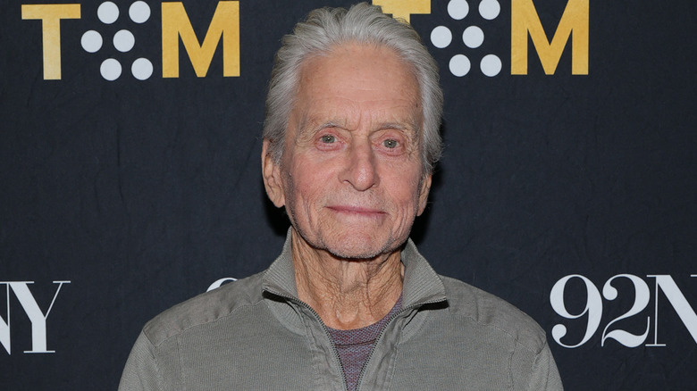 Michael Douglas draagt ​​een grijze outfit op een rode loper