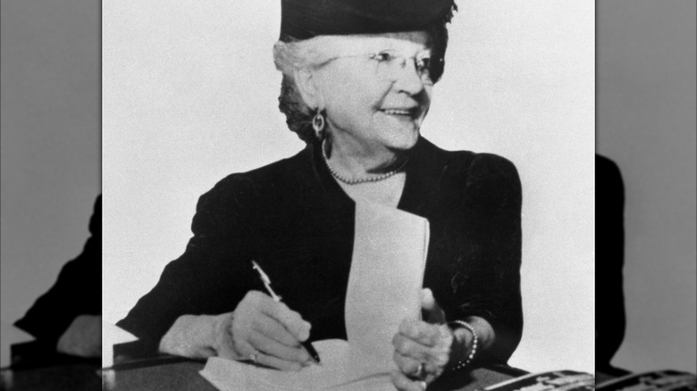 zwart-witfoto van Laura Ingalls Wilder die een boek signeert